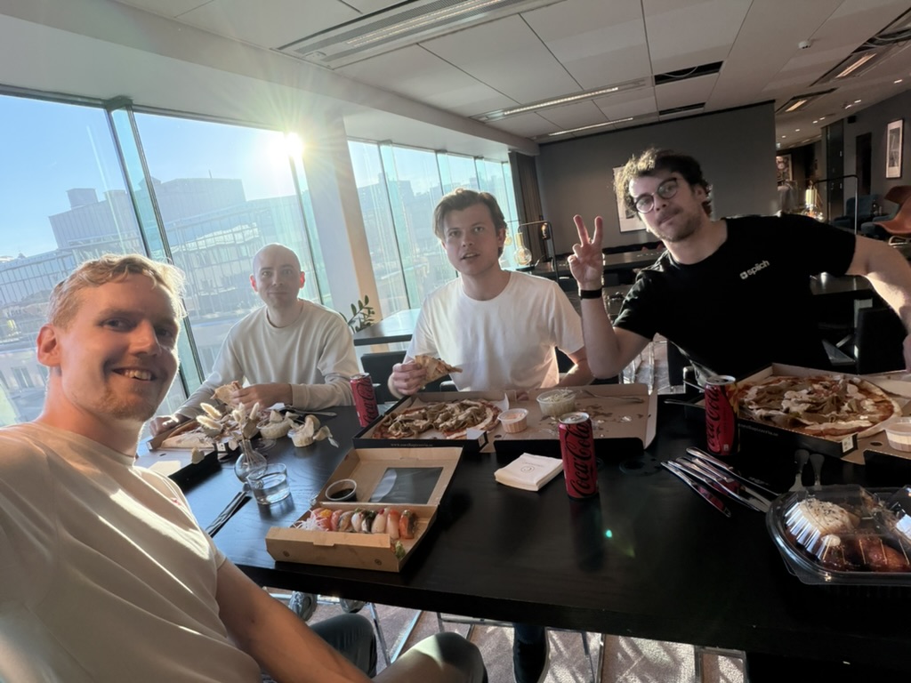 The team sharing pizza and sushi around the office dinner table